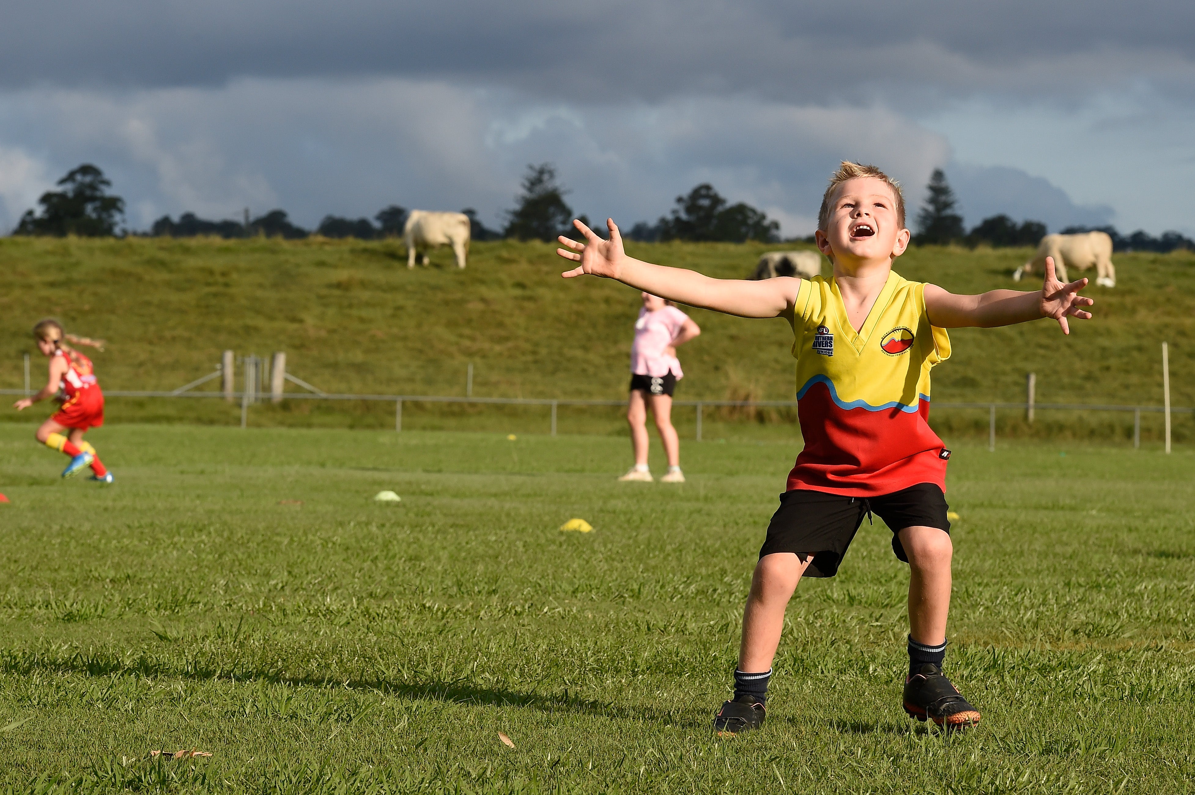 A young footballer waits to catch the ball during a football training session.